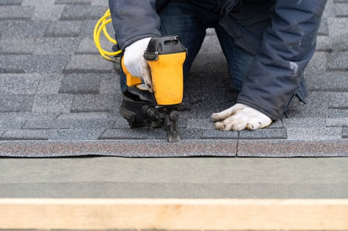 Roofer laying shingles